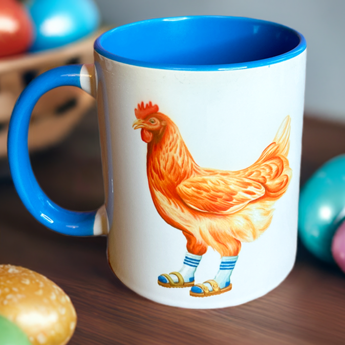 Mug with a colorful rooster design on a wooden surface with Easter eggs.