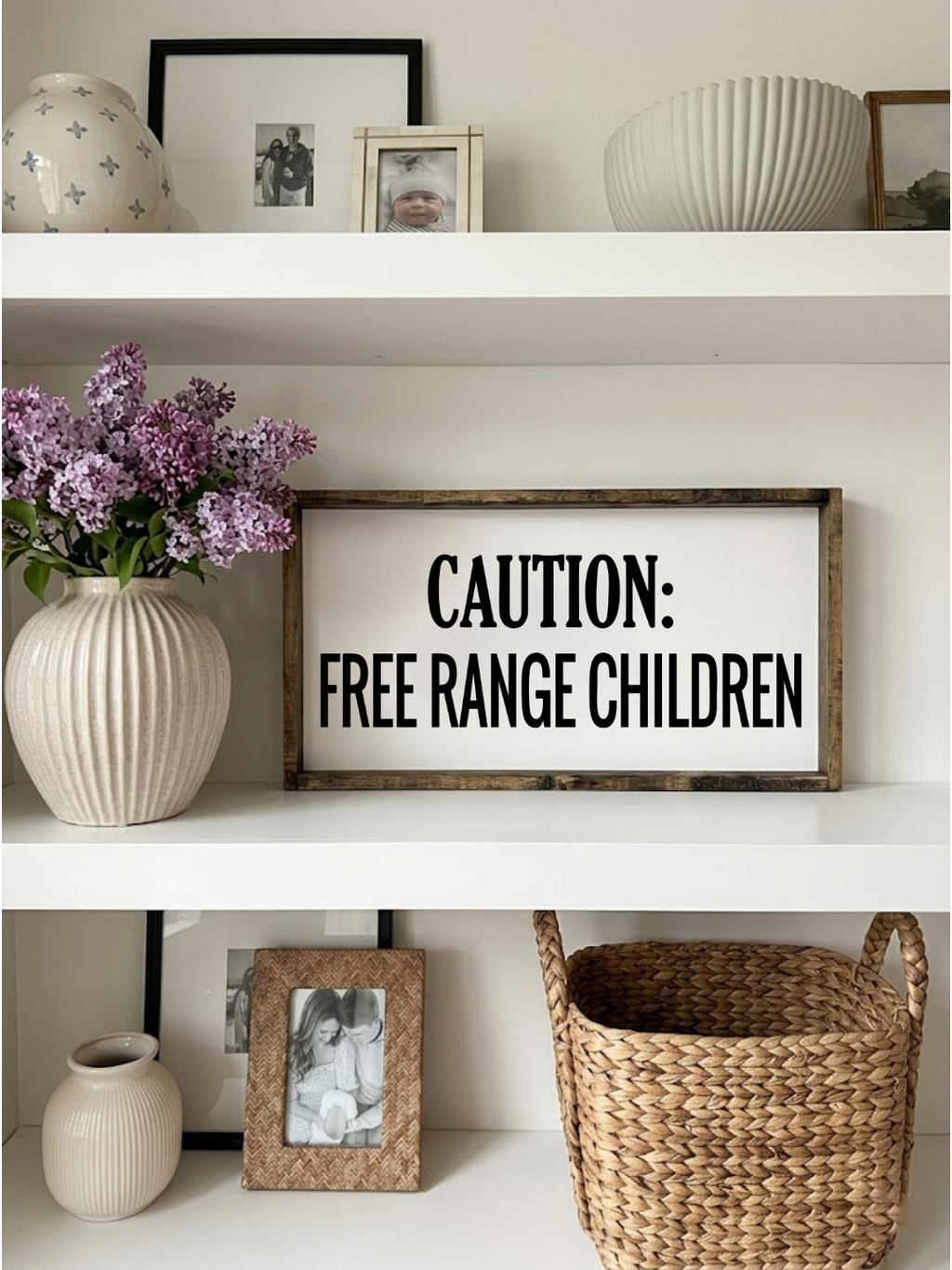 Decorative shelf with a sign reading 'CAUTION: FREE RANGE CHILDREN', vases, and a basket.