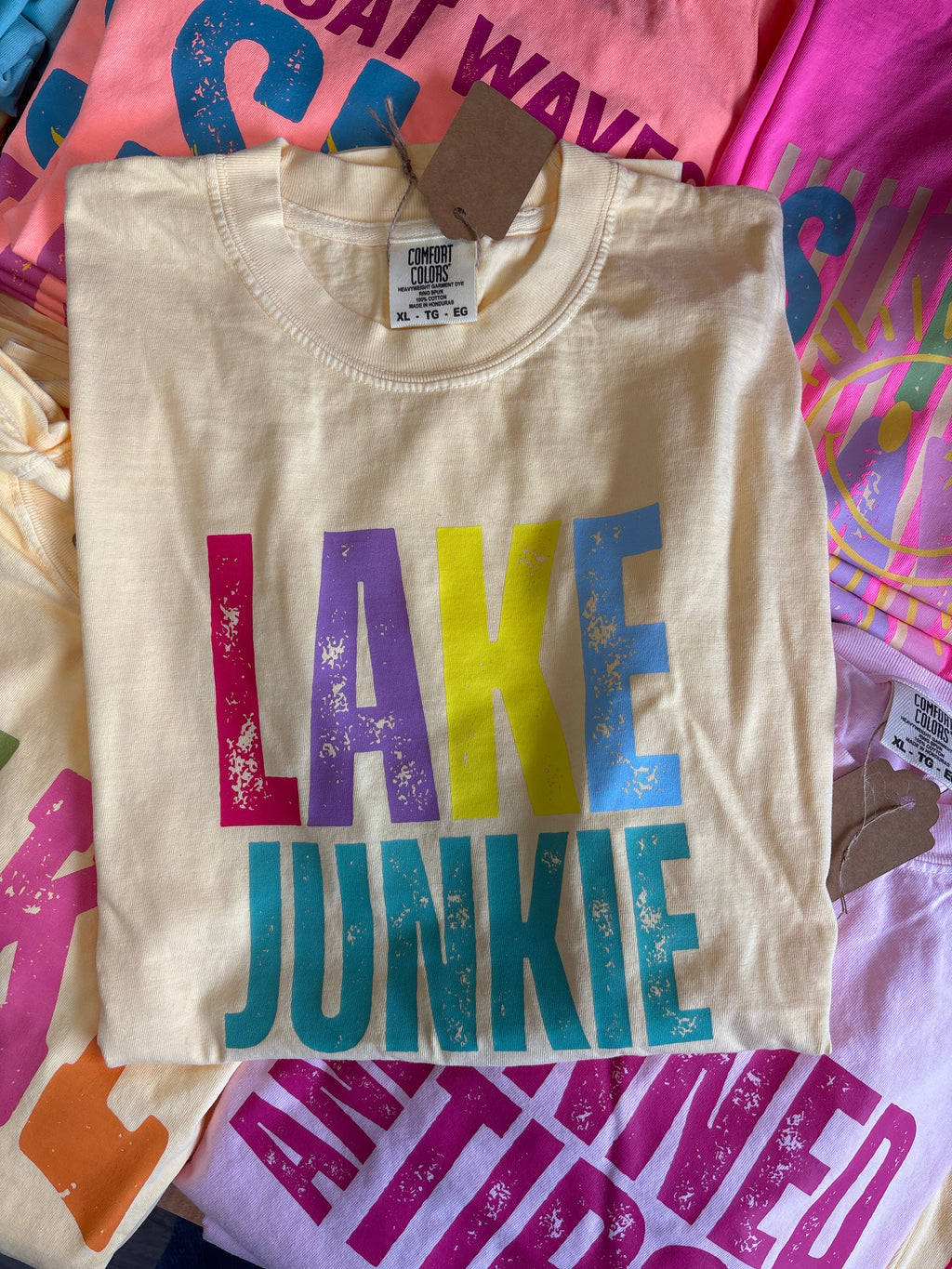 Beige t-shirt with colorful text on a multicolored background