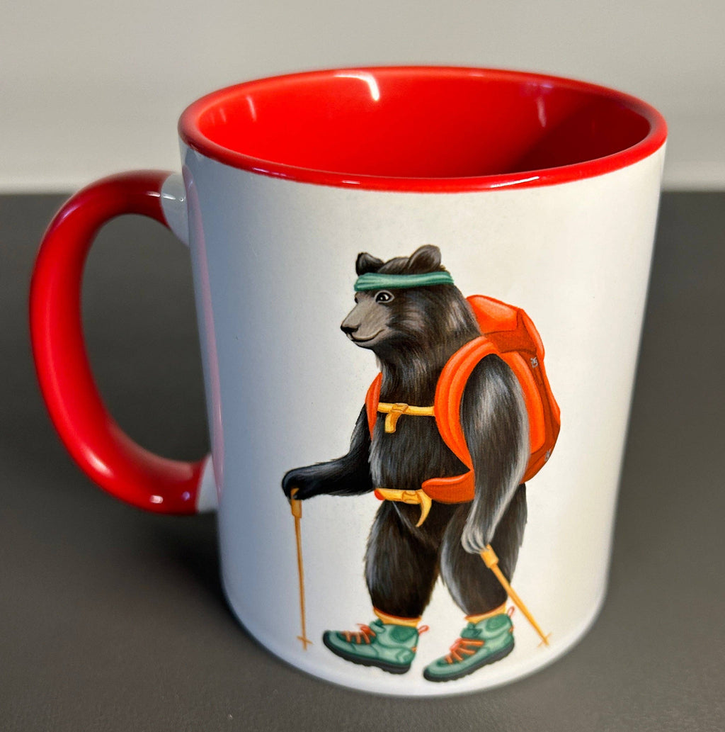 Mug with a bear design wearing a life jacket and hiking boots on a gray surface.