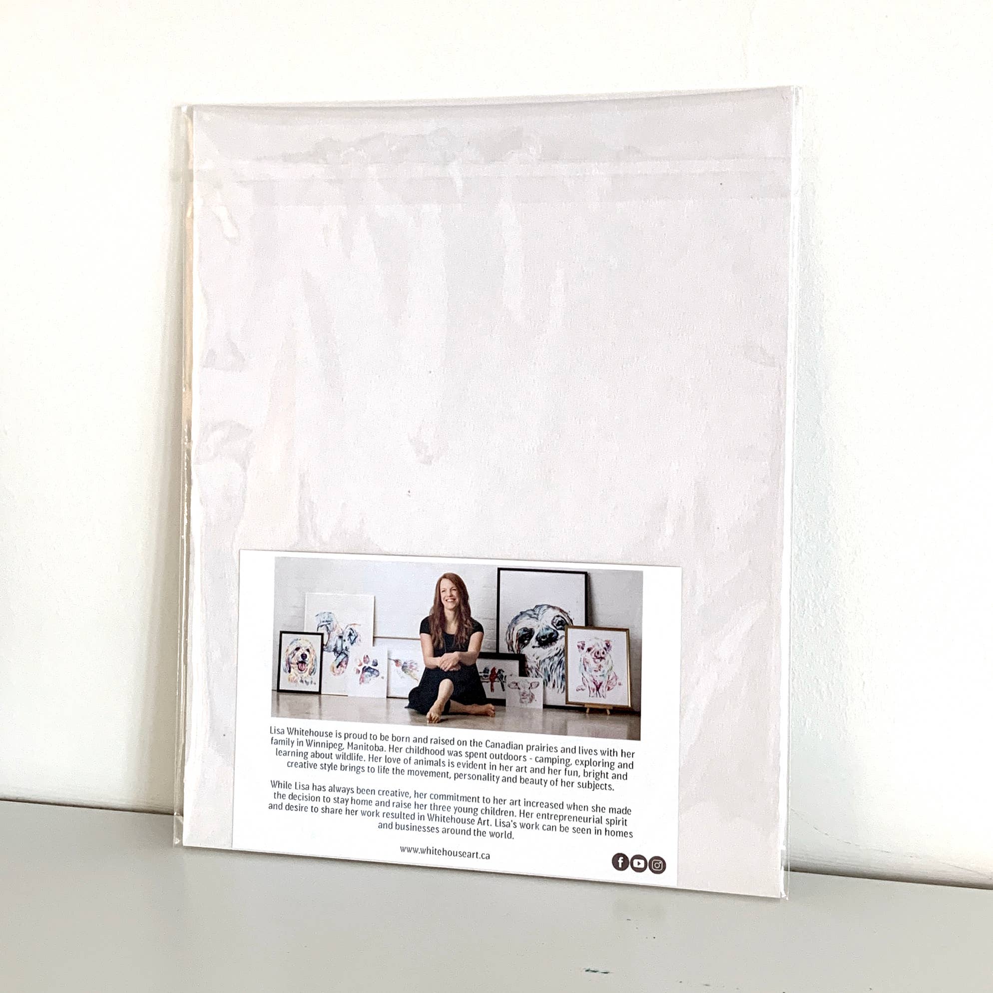 Framed photo of a woman sitting on a couch with framed pictures around her, displayed on a white background.