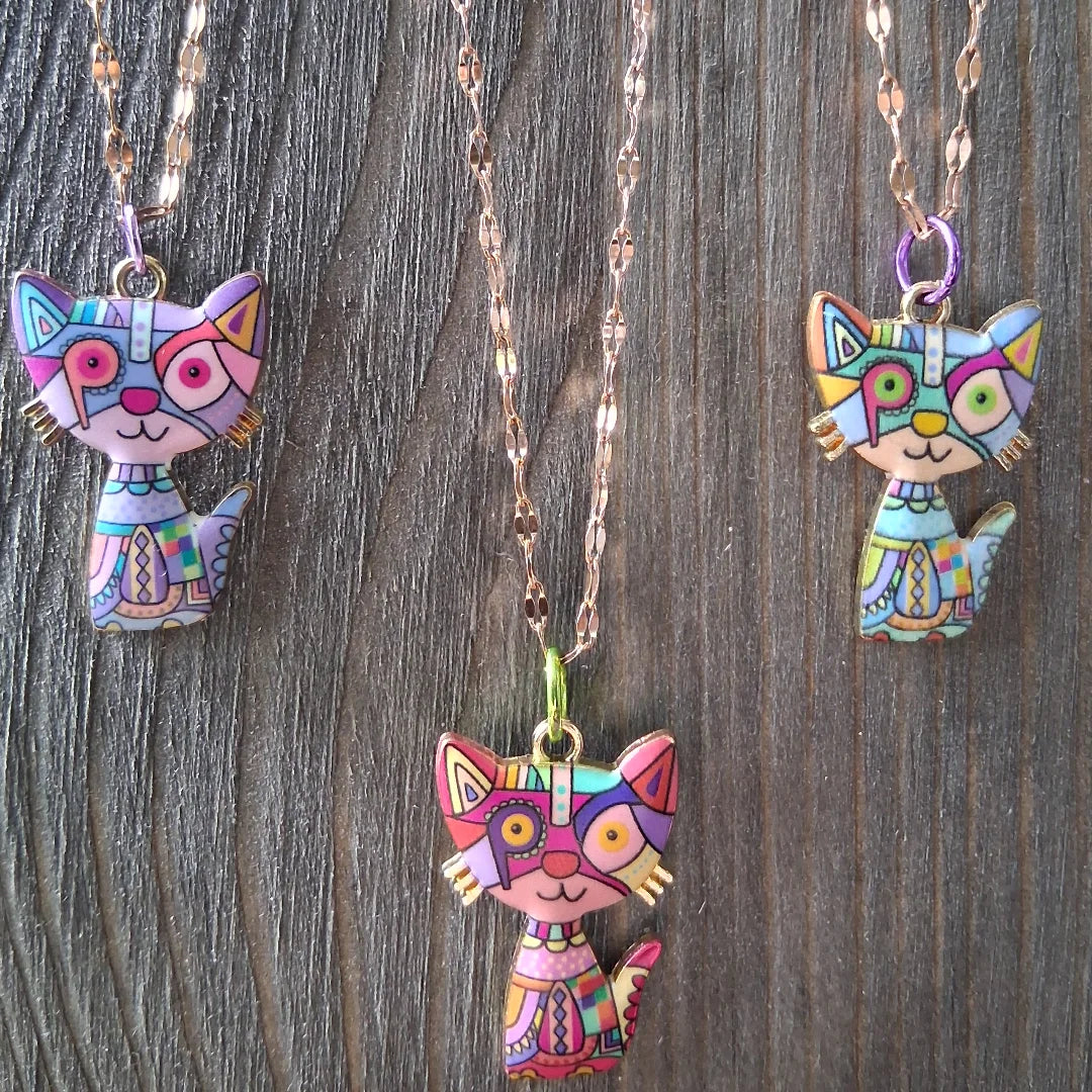 Colorful cat-shaped pendants on chains against a wooden background