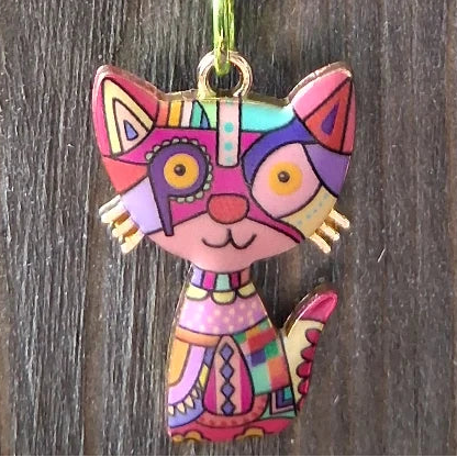 Colorful cat-shaped pendants on chains against a wooden background