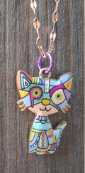 Colorful cat-shaped pendants on chains against a wooden background