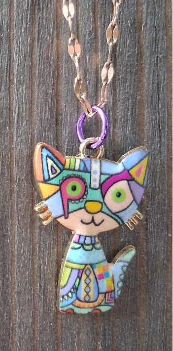 Colorful cat-shaped pendants on chains against a wooden background