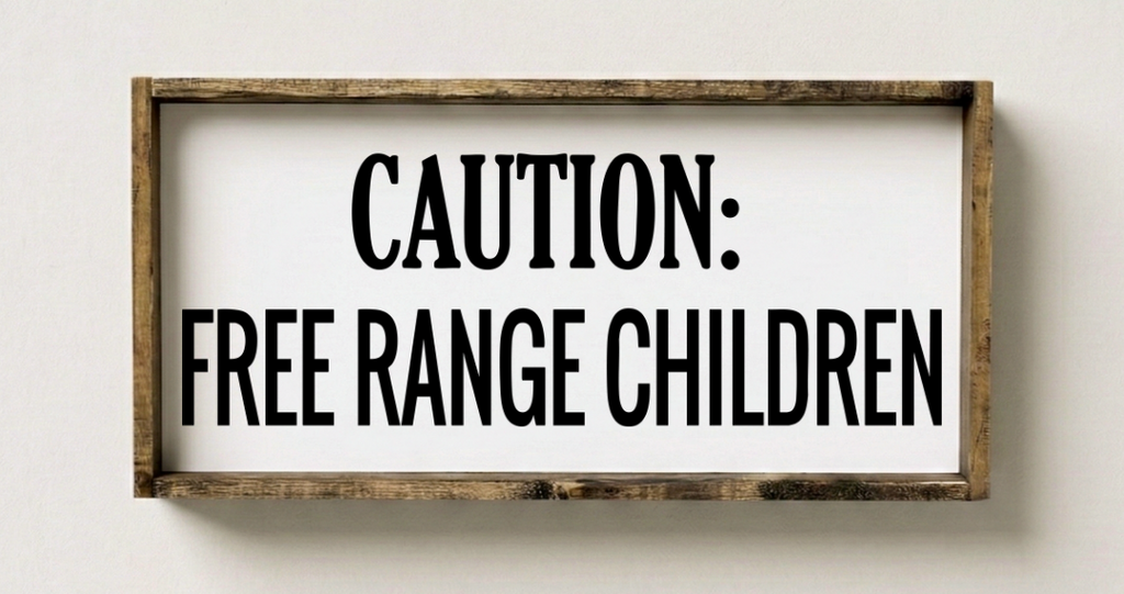 Wooden sign with 'Caution: Free Range Children' text on a white wall