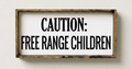 Wooden sign with 'Caution: Free Range Children' text on a white wall