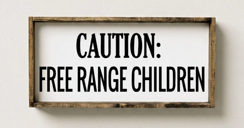 Wooden sign with 'Caution: Free Range Children' text on a white wall
