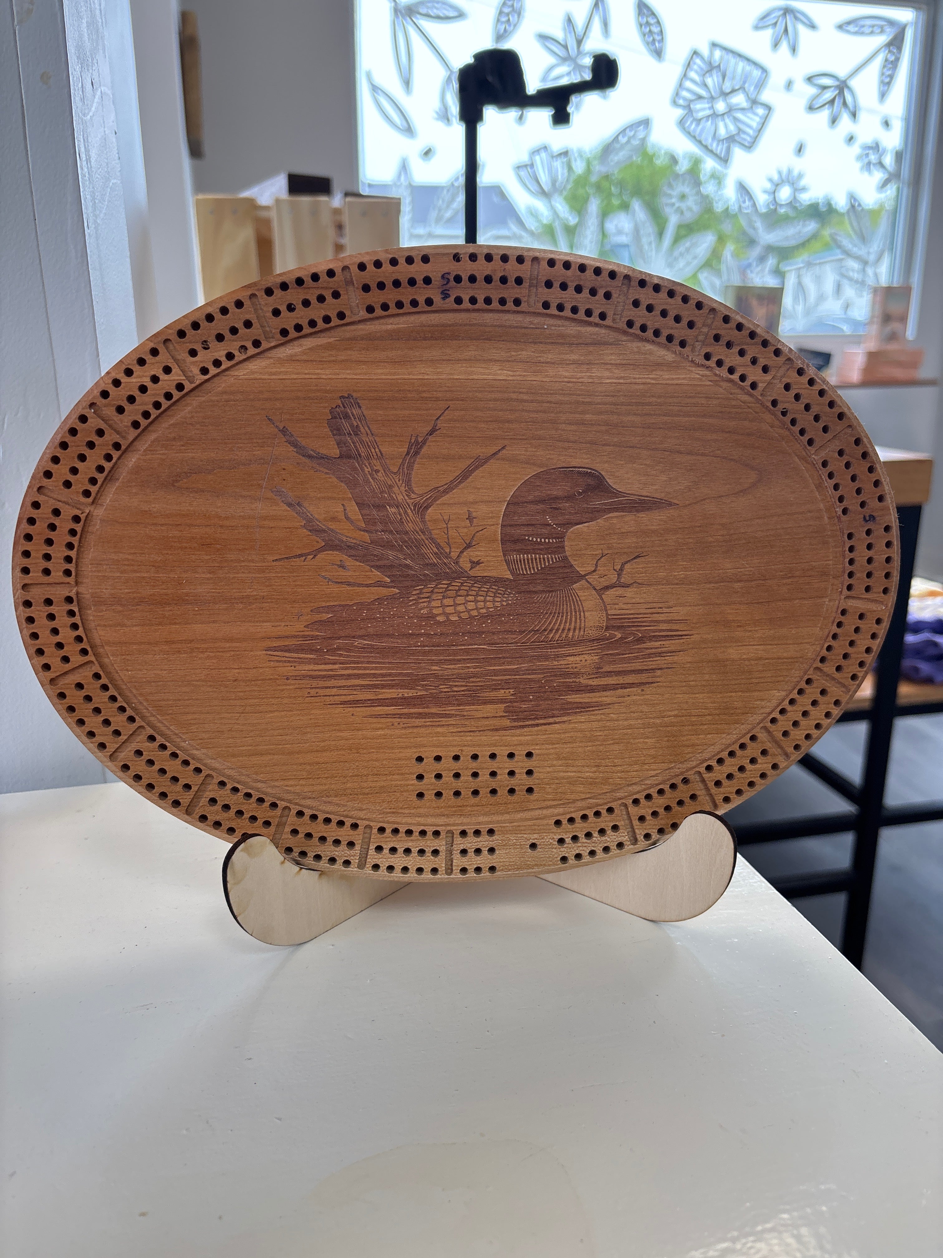 Wooden coaster with engraved design on a white surface