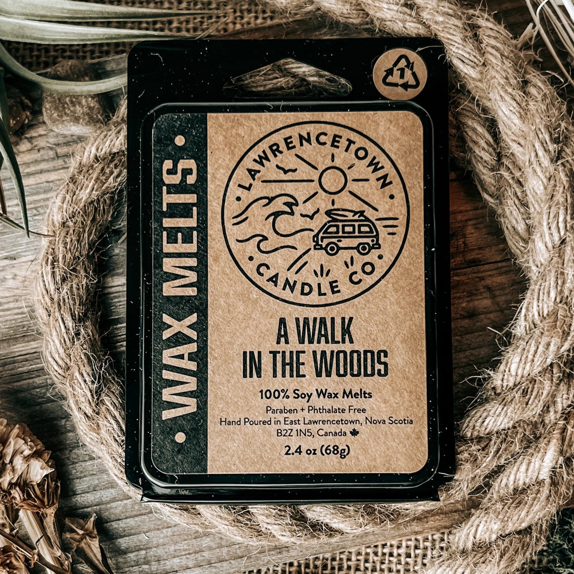 A single wax melt package labeled 'A WALK IN THE WOODS' by Lawrence Town Candle Co., placed on a rustic wood surface with burlap and rope props.
