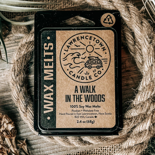 A single wax melt package labeled 'A WALK IN THE WOODS' by Lawrence Town Candle Co., placed on a rustic wood surface with burlap and rope props.