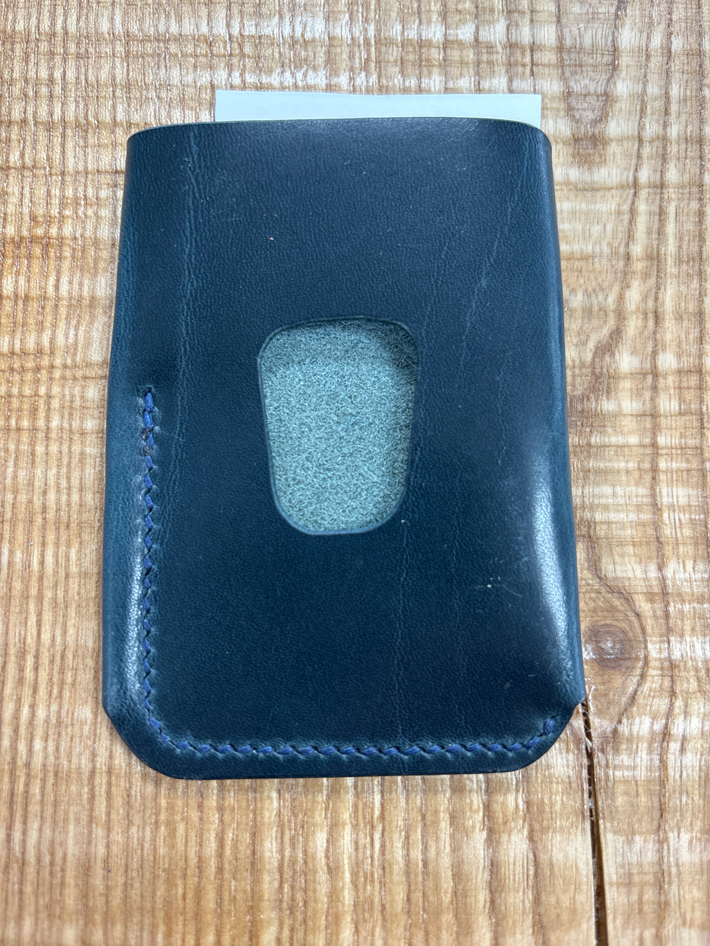 Blue leather cardholder on a wooden surface