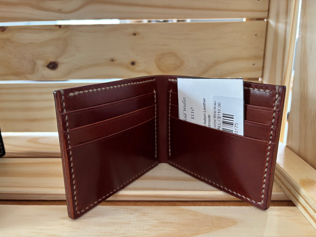 Brown leather wallet with card slots on a wooden surface