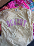 BUTTER t-shirt with 'BEACHY' text in pink on a colorful background