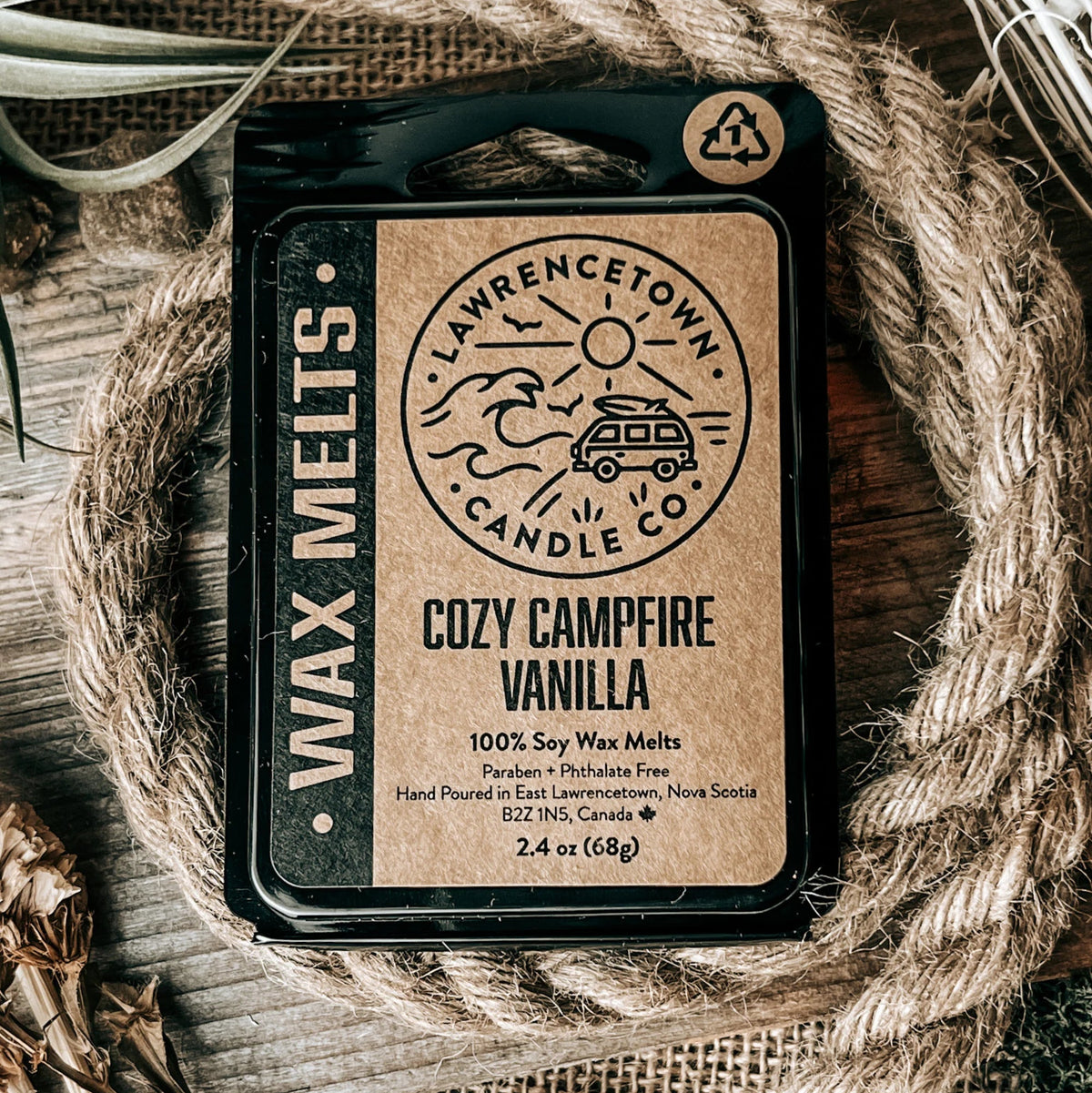 A package of Laurencetown Candle Co. Cozy Campfire Vanilla wax melts, presented in a rustic flat-lay setting with a coiled jute rope, burlap, and dried grass on a wooden surface.