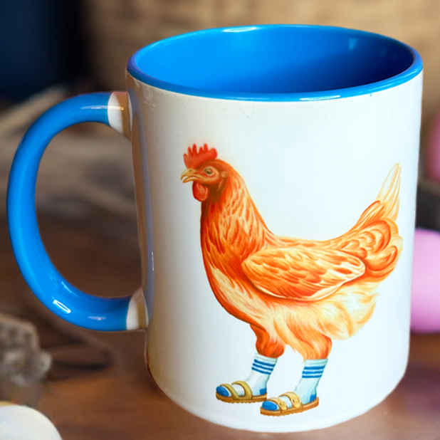 Mug with a rooster design on a wooden surface with Easter eggs.