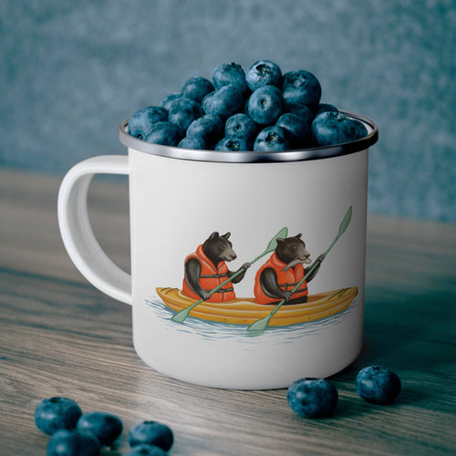 Mug with bear illustration filled with blueberries on a wooden surface.