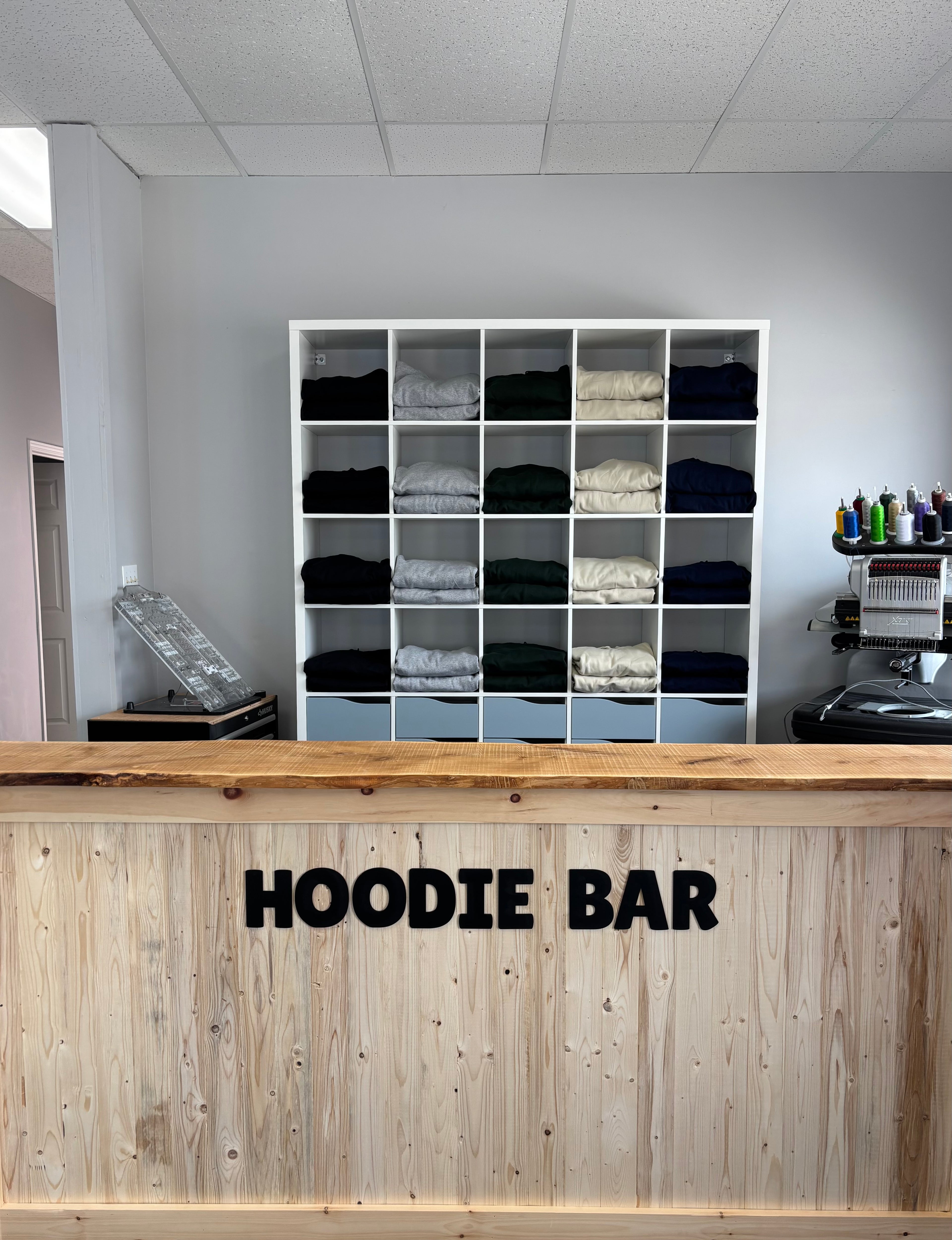 Hoodie Bar with clothing racks and a counter in a store setting