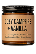 Candle jar labeled 'Cozy Campfire + Vanilla' on a white background