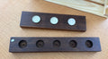 Two wooden blocks with circular holes on a wooden surface